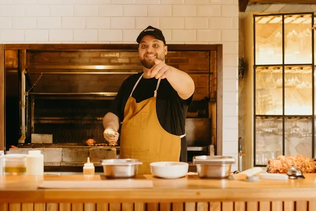 a chef in kitchen cooking while smiling